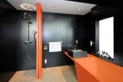 Residential Shower Wall, Sink Surround and Vanity Top with Integrated Solid Surface Tub. of LG HI_MACS Black and Florida Orange Solid Surface