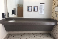University of California San Diego Gym Restroom Countertop in Solid Surface with Undermount Porcelain Sink, Coved Backsplash, and  Front Apron 1
